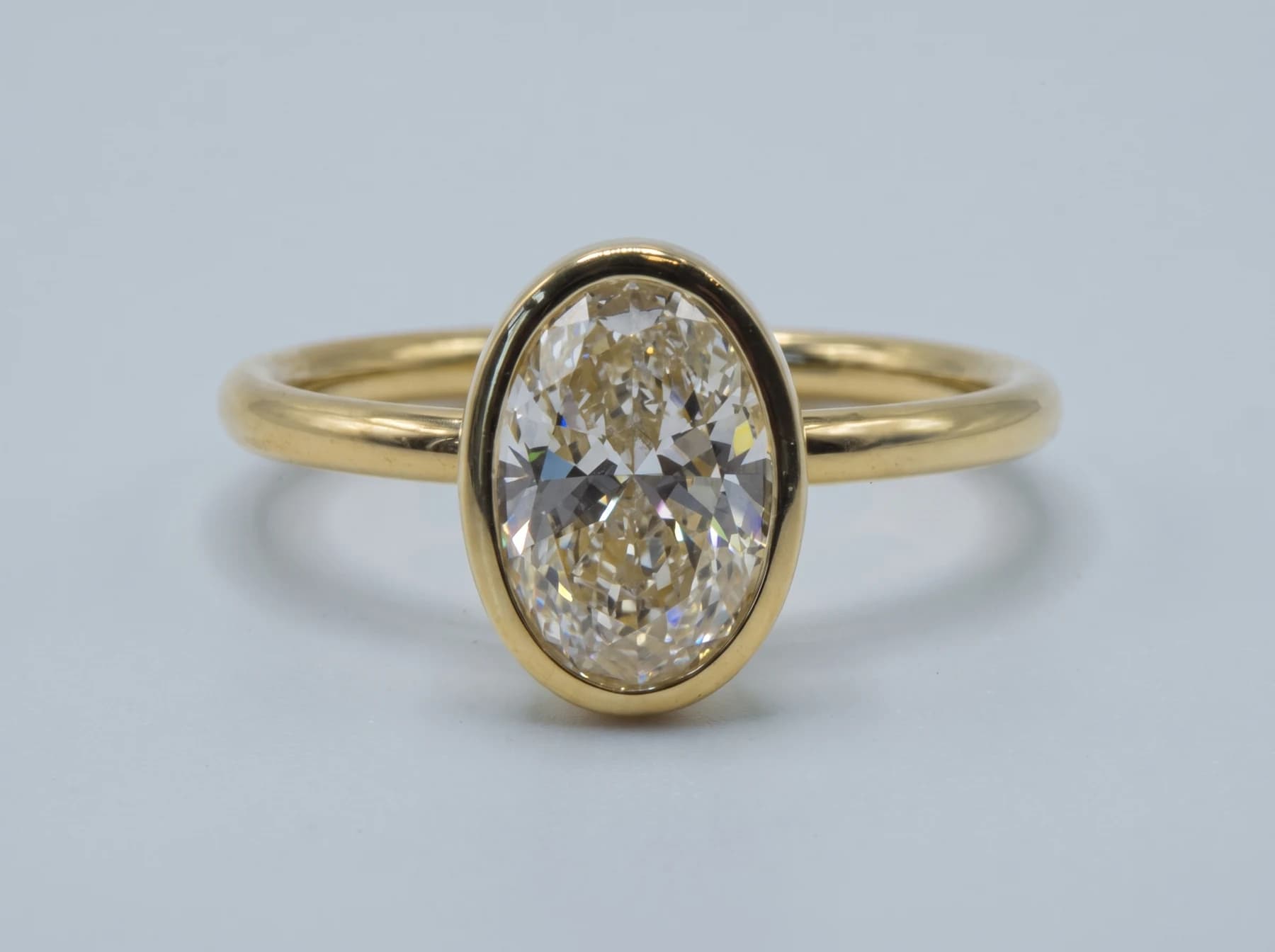 Oval stone in a yellow-gold bezel ring